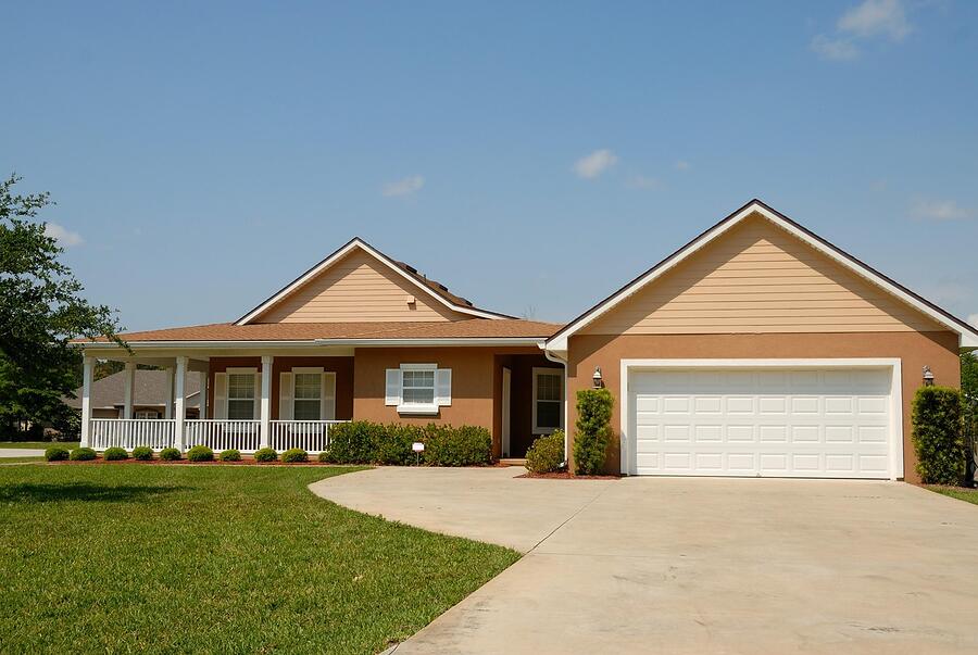 A single-story block and stucco house with a two-car garage