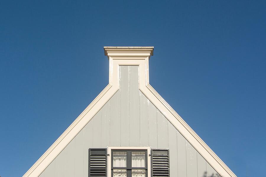 A louvered gable vent high on a white gable end